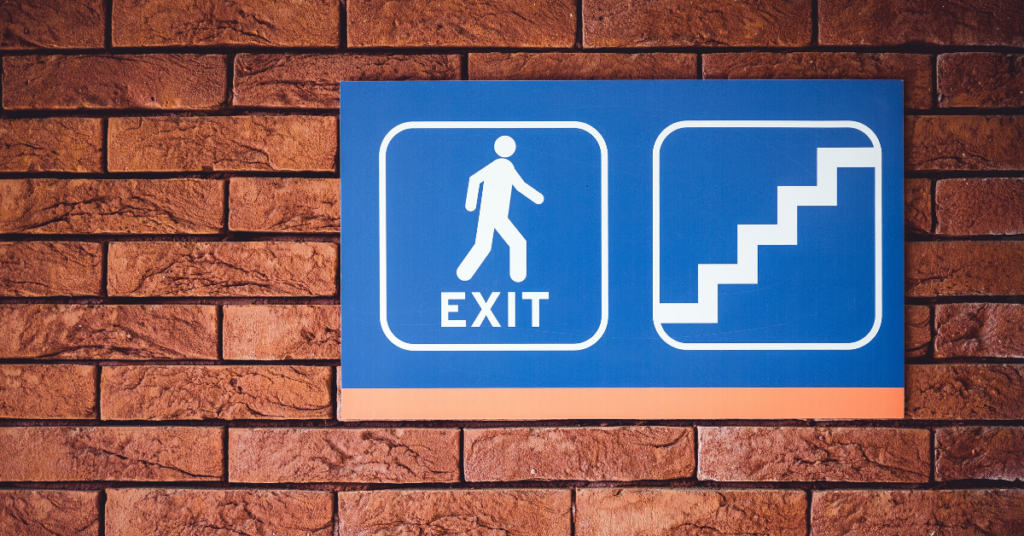 brick wall with blue exit stair sign