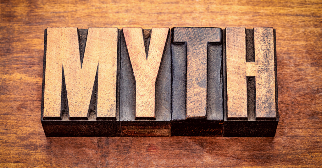 word MYTH spelled in printing blocks on wooden surface